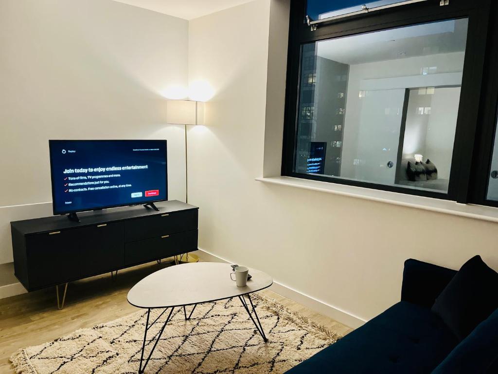 曼彻斯特Brand new modern 1 bed apartment near Old Trafford Stadium的客厅配有电视和茶几