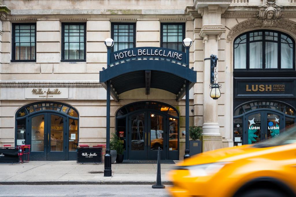 纽约Hotel Belleclaire Central Park的一辆黄色的出租车经过酒店大楼