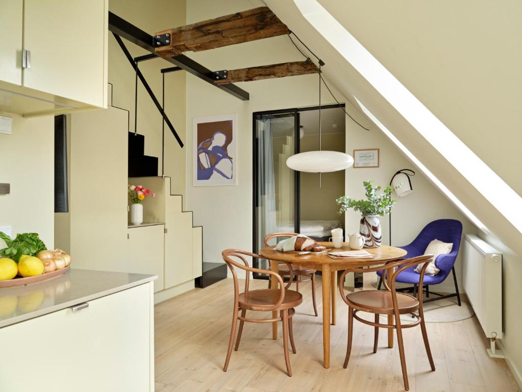 哥本哈根Apēron Apartment Hotel的厨房以及带桌椅的用餐室。