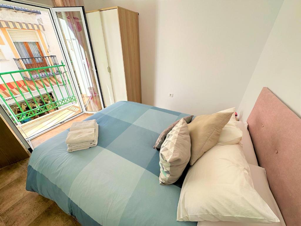 内尔哈卡萨贾斯敏公寓的卧室配有带枕头的床铺和窗户。