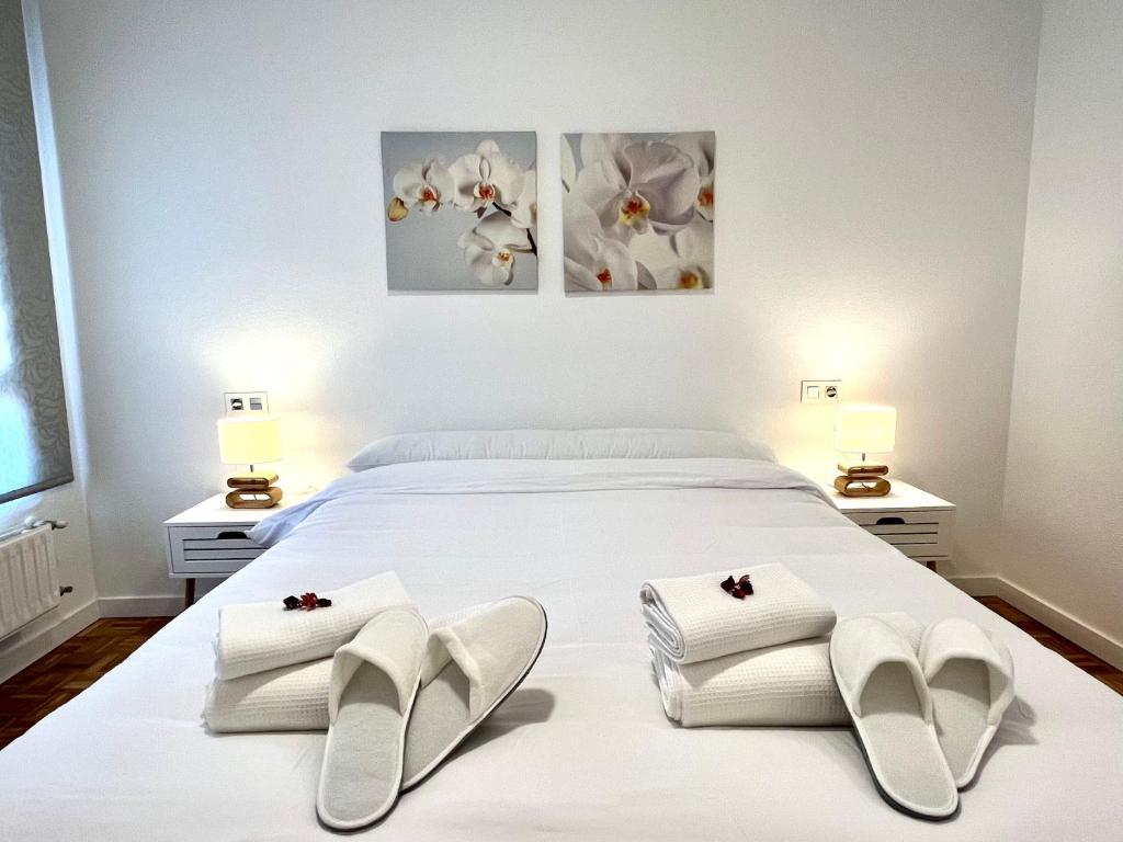 CastandielloAngliru 1 Suite的卧室配有白色床、白色毛巾和两盏灯。