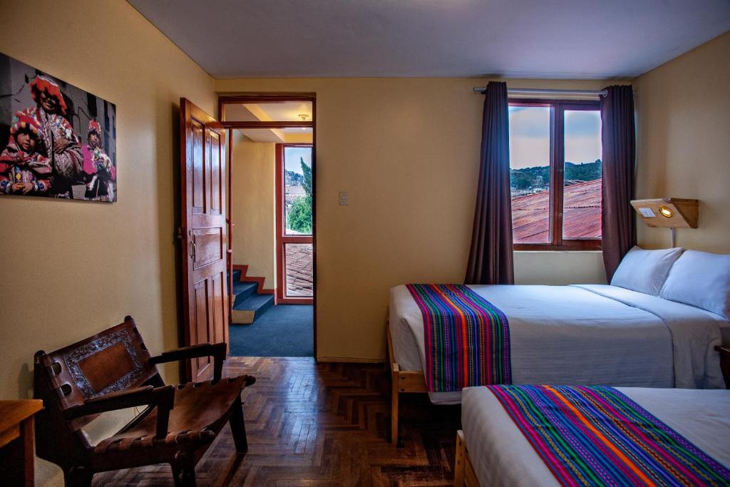 库斯科Eco Inn的酒店客房设有两张床和窗户。