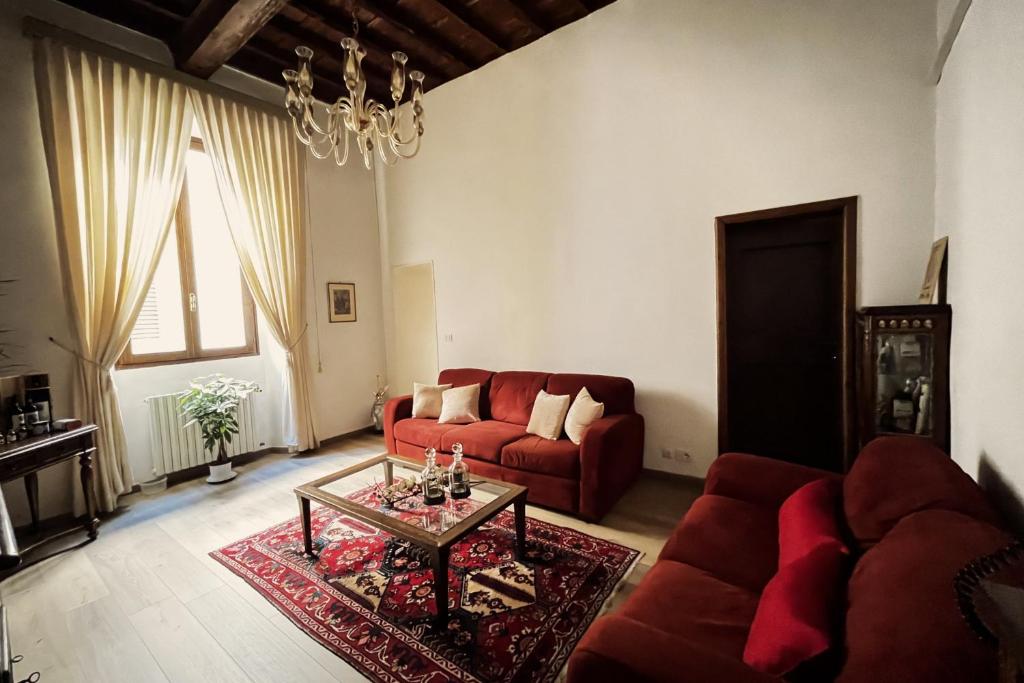 佛罗伦萨Da Mario in Florence Guesthouse的客厅配有红色的沙发和桌子