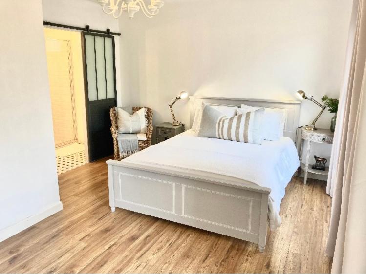 Bourg-CharenteStunning bedroom overlooking the Charente的卧室配有白色的床和椅子