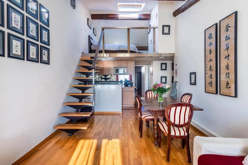 尼斯Samourai Massena Lodge -1 min from the sea的厨房以及带螺旋楼梯和桌椅的用餐室。