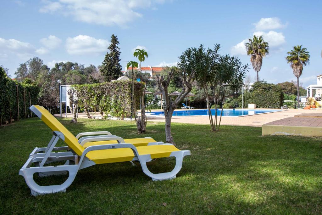 阿尔布费拉Oura 7的游泳池附近的草地上一张黄色和白色的躺椅