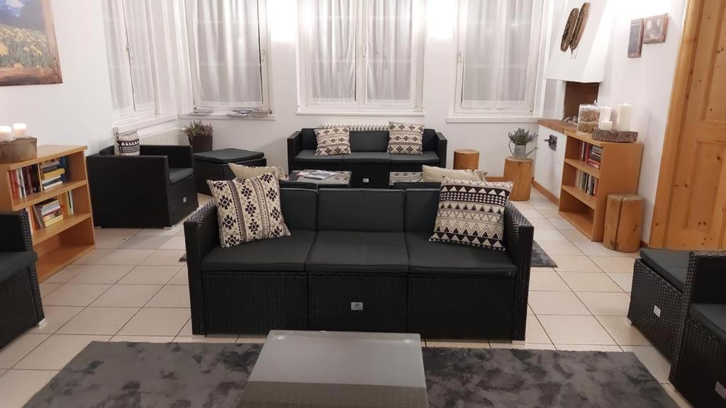 马津索吉奥诺德罗米特酒店的客厅配有黑色沙发和椅子