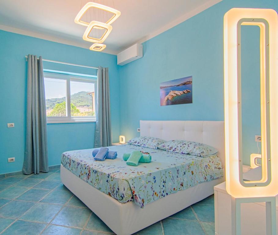 费拉约港Appartamenti Mare Portoferraio的一间蓝色卧室,配有一张床和镜子