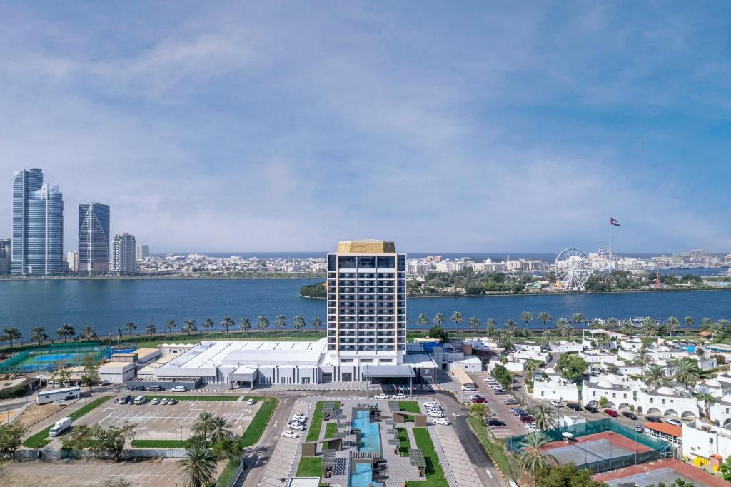 沙迦假日国际酒店的水体旁的一座高大的白色建筑