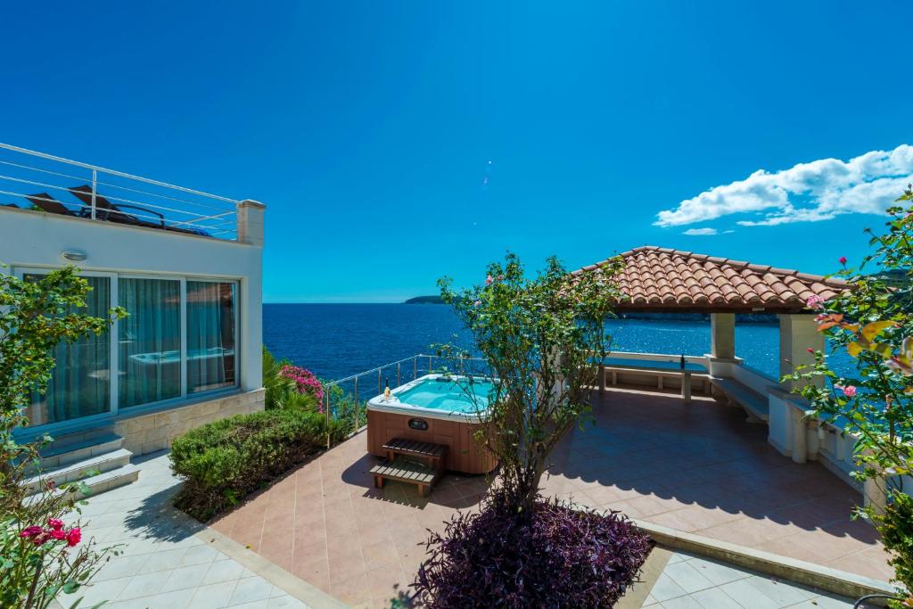 杜布罗夫尼克Villa Vacanza Dubrovnik - Five Bedroom Villa with Private Sea Access的一座带热水浴缸和大海的房子