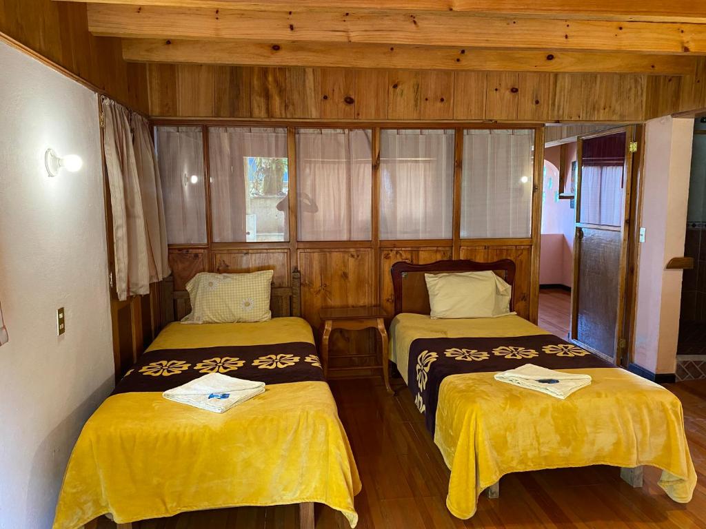 库埃察兰德尔普罗格雷索Posada Quetzalin的木墙客房的两张床