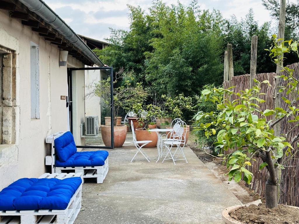 尼姆CASA AZUL - jardin, calme, tennis的庭院配有2把蓝色的椅子和桌子