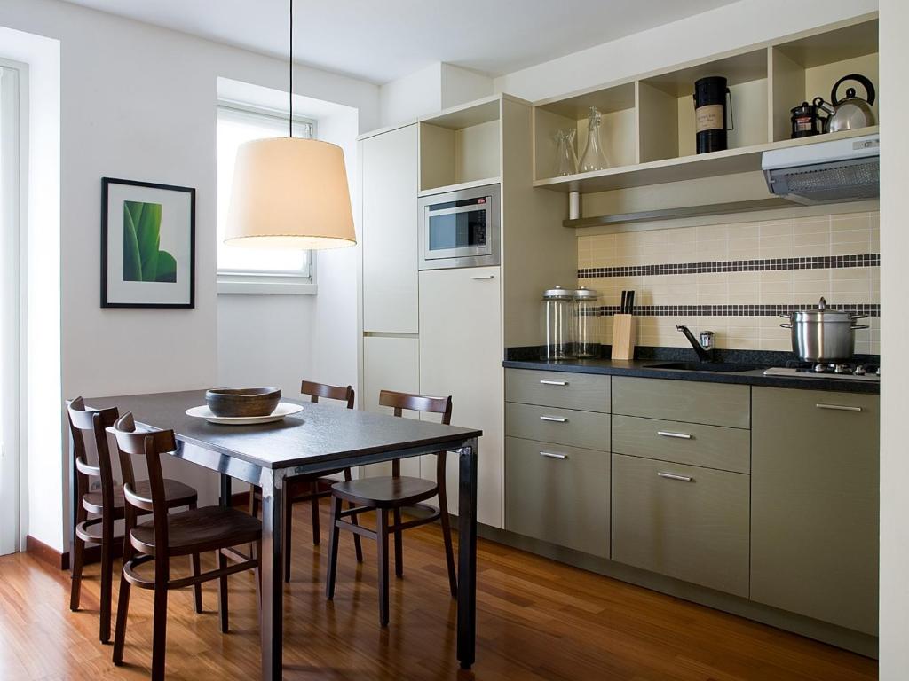 贝拉吉奥Nenè-Il Vicolo Apartments and Rooms的厨房以及带桌椅的用餐室。