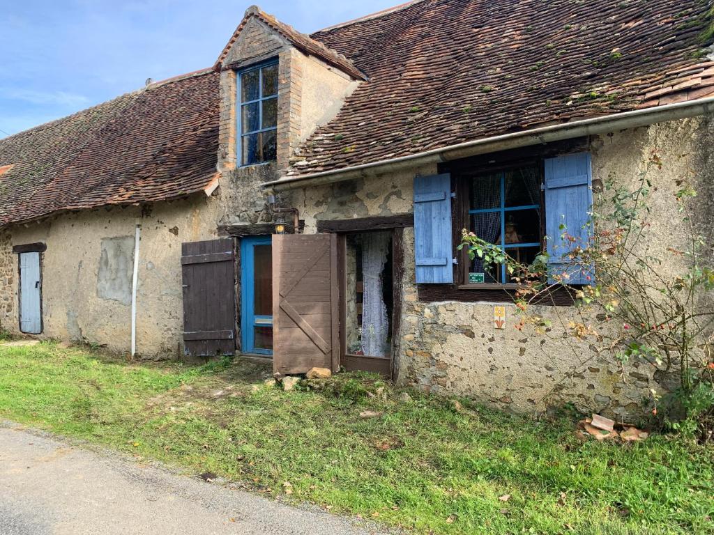 TholletLe petit cottage的一座古老的石头房子,设有蓝色的门和窗户