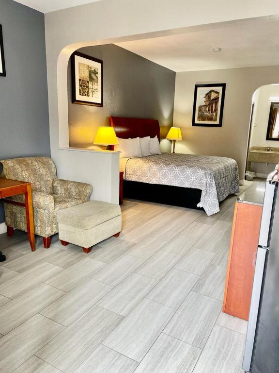 孟菲斯American Way Inn & Suites的配有一张床和一把椅子的酒店客房