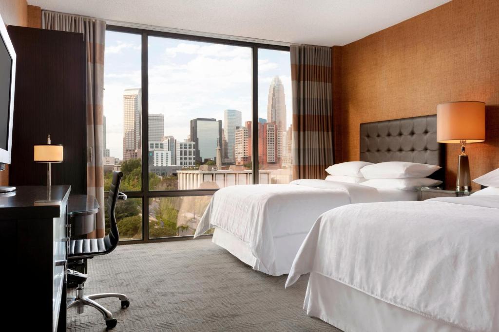 夏洛特夏洛特喜来登酒店的酒店客房设有两张床和大窗户。