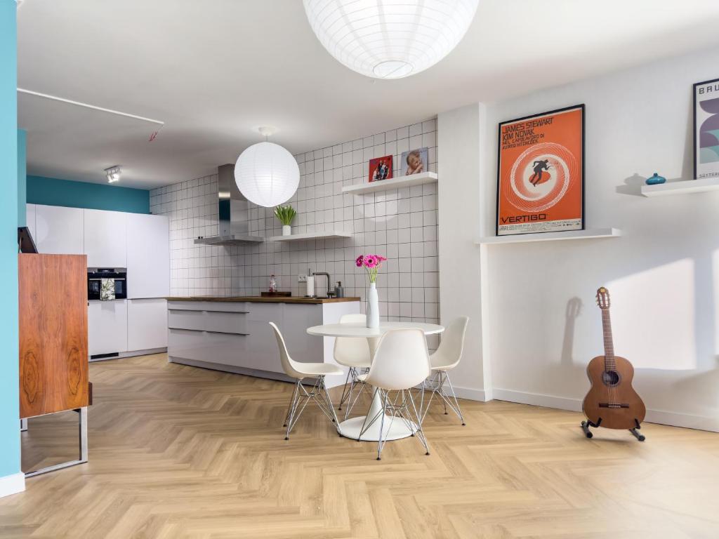 鹿特丹Rotterdam's coolest apartment的厨房以及带桌子和吉他的餐厅。
