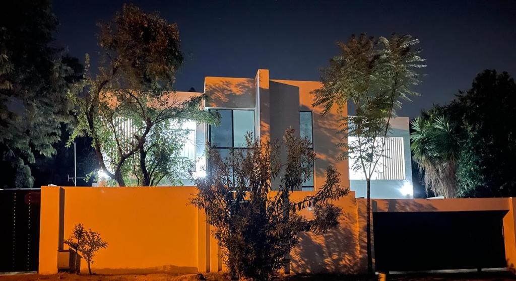 鲁德普特Stay In Carlazo - Unlimited WiFi, Solar backup的一座在晚上有橘子墙和树木的房子