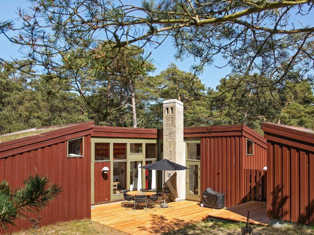 维斯特索马肯Three-Bedroom Holiday home in Nexø 38的装有甲板和房子的红色集装箱