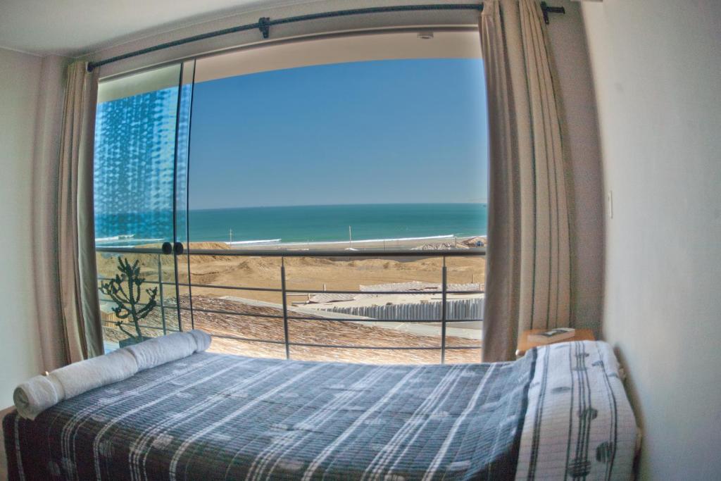 洛维托斯萨尔瓦多韦科旅馆的一间卧室设有窗户,享有海滩美景