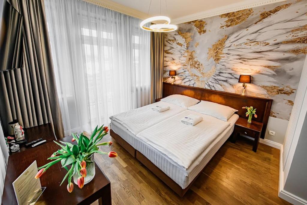 下乌斯奇基尼夫别墅酒店的卧室配有一张床,墙上挂着一幅大画