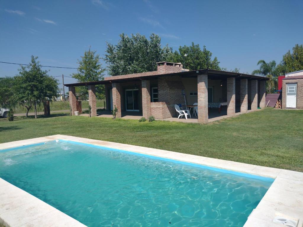 拉斐拉Casa de campo Los Cardenales的房屋前的大型游泳池