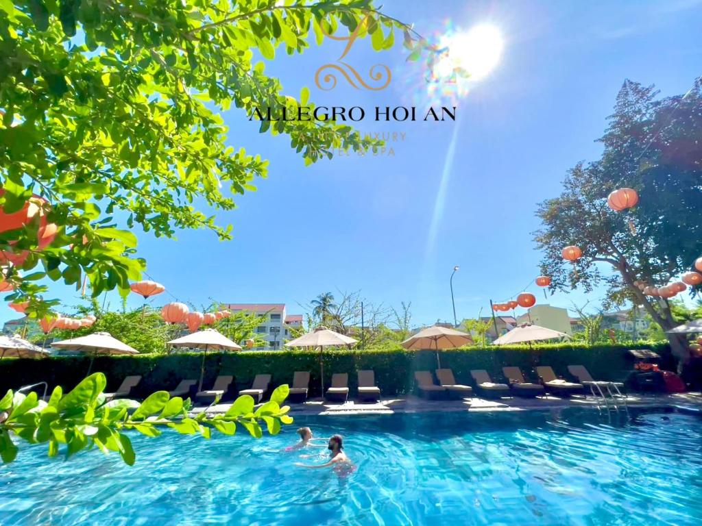 会安Allegro Hoi An . A Little Luxury Hotel & Spa的和水中的人在度假村的游泳池