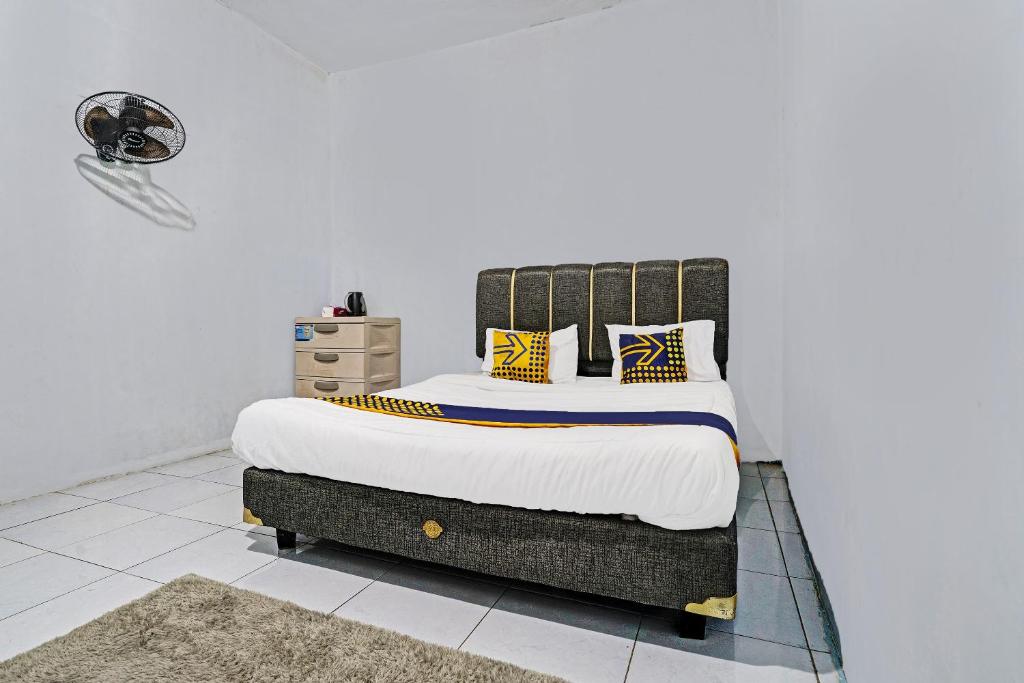 伦邦OYO 92269 Arjuna Homestay的一间卧室配有一张大床,提供黄色和蓝色的枕头