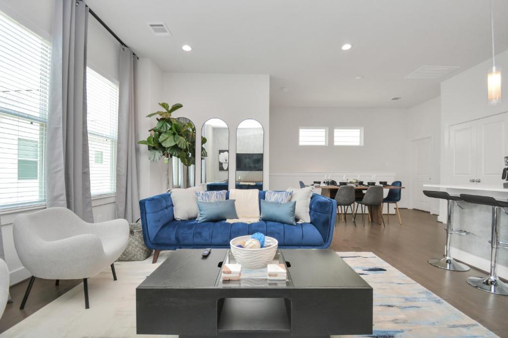 休斯顿Casa Azure - New Modern 3 BR, Med Center, NRG, UH的客厅配有蓝色的沙发和桌子