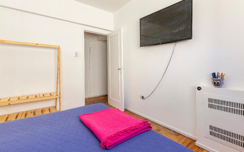 科尔多瓦Habitacion Privada en depto centro的一间房间,床上有粉红色枕头