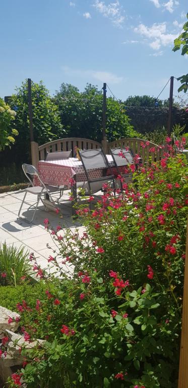 普洛默迪耶尔恩Maison Papillons的花园配有桌椅和鲜花