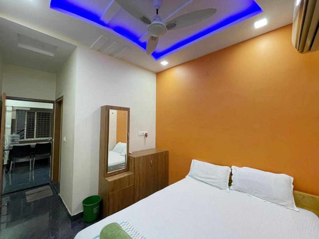 亨比Vijayanagara Home Stay的一间卧室配有一张床和吊扇