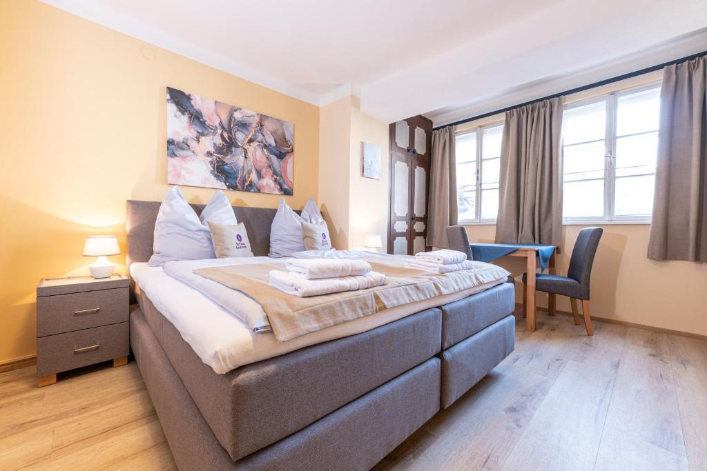 萨尔茨堡辛德布尔旅馆的一间卧室配有一张大床和一张书桌