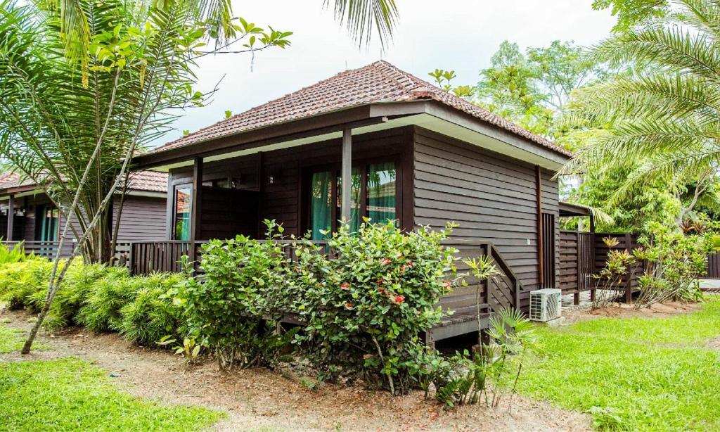 新加坡Kranji Sanctuary Resort的一座小房子,在院子里有树木和植物
