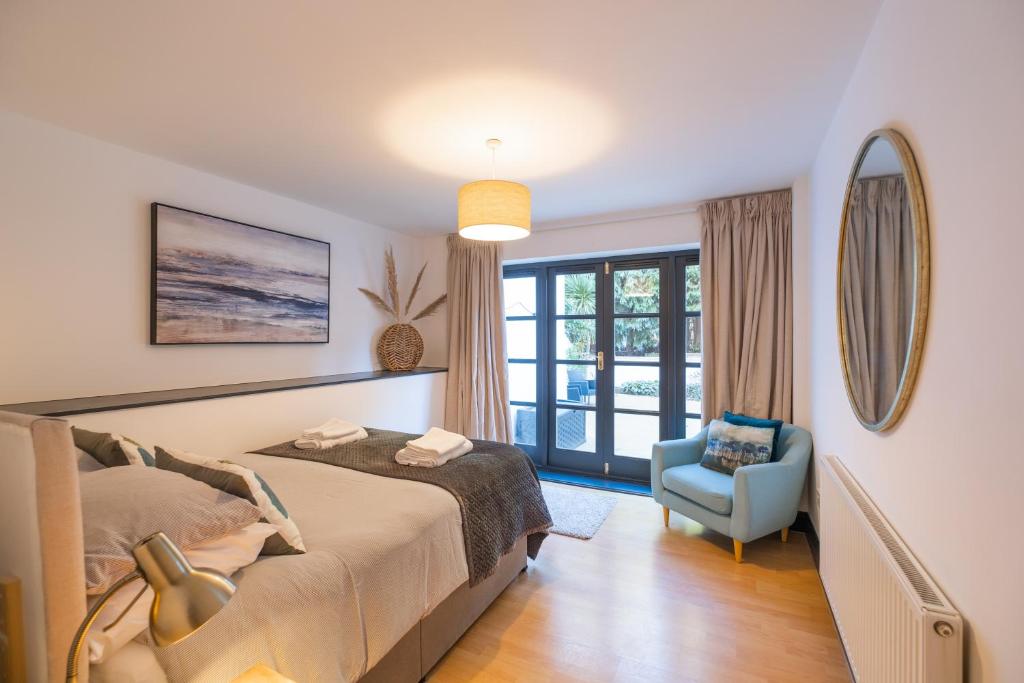 伯恩茅斯Modern apt near gardens with large decking area - Vivre Retreats的一间卧室配有一张床和一张蓝色椅子