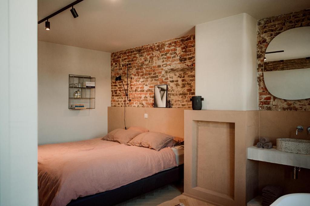 MaarkedalPlein 11的一间卧室设有一张床和砖墙
