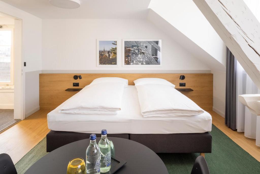 苏黎世Fred Hotel Zürich Hauptbahnhof的一间卧室配有一张床和一张桌子,上面装有瓶子