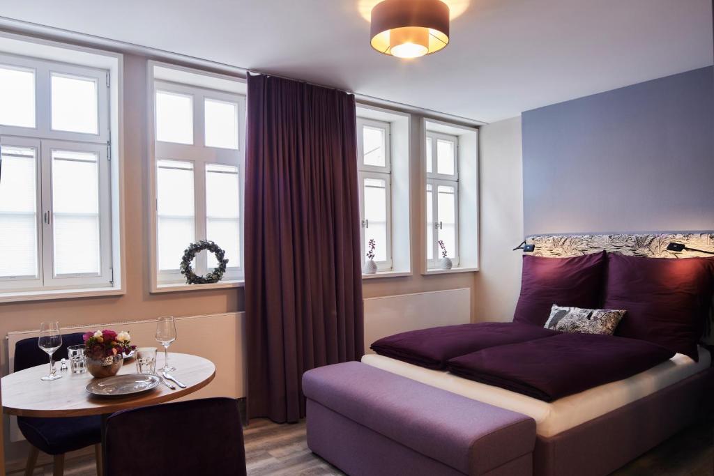 富尔达Fachwerk-Romantik am Dom的卧室配有床、桌子和窗户。