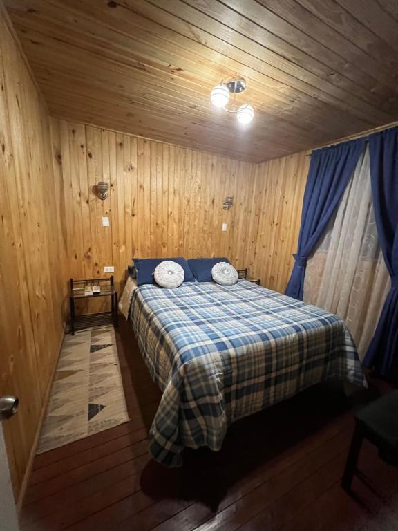 El TorreónCabañas Vista Hermosa Radal 7 Tazas的小木屋内一间卧室,配有一张床