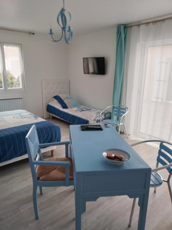 滨海拉普兰bord de mer的一间设有两张床和一张蓝色桌子及椅子的房间