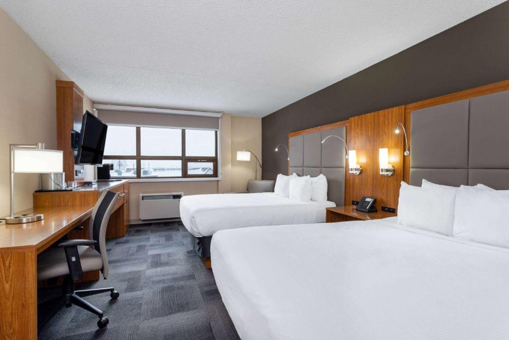 圣约翰堡Ramada by Wyndham Northern Grand Hotel & Conference Centre的酒店客房配有两张床和一张书桌