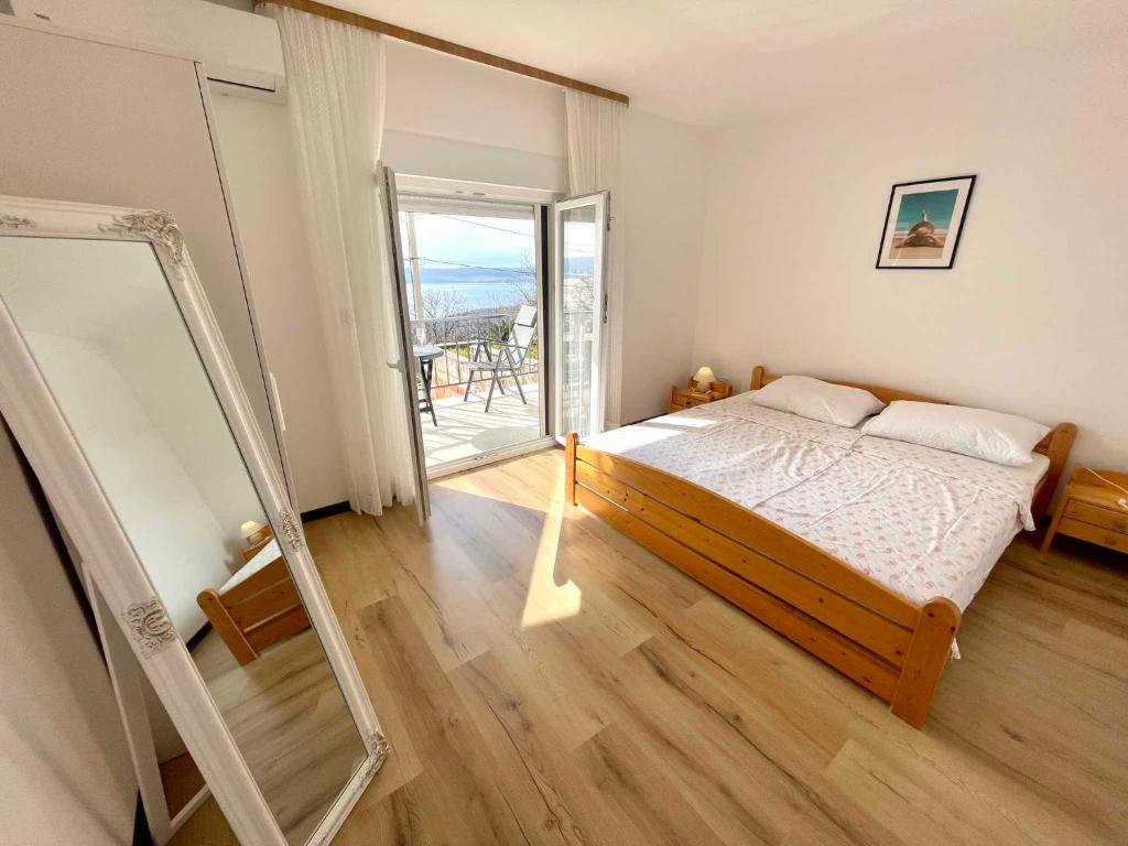 德拉马利Apartments in Dramalj 42940的一间带床和镜子的卧室以及一个阳台