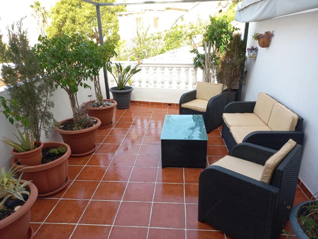 阿尔姆尼卡Casa Gran Tropicana playa a 2 minutos.的庭院配有桌椅和盆栽植物