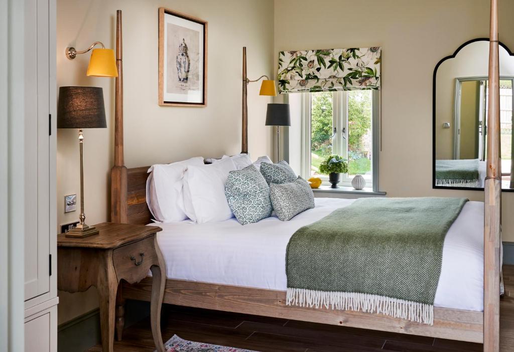 博利厄蒙塔古阿姆斯酒店的一间卧室配有一张床、一张桌子和一个窗户。