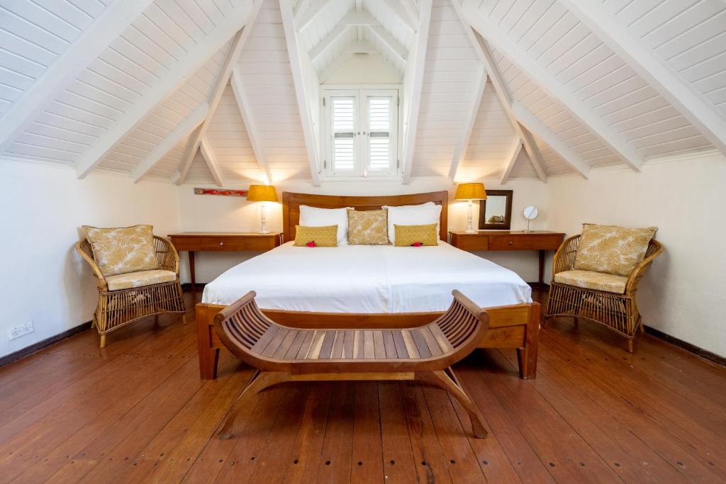 威廉斯塔德Sirena Bay Estate的一间卧室配有一张大床和两把椅子