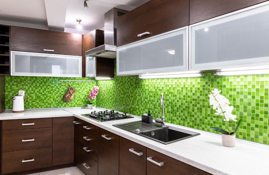 华沙ClickTheFlat Piękna Center Apart Rooms的厨房设有水槽和绿色瓷砖墙。