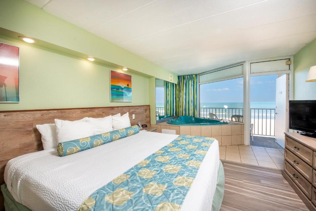 弗吉尼亚海滩帆船旅馆的一间卧室配有一张床、一台电视和一个阳台