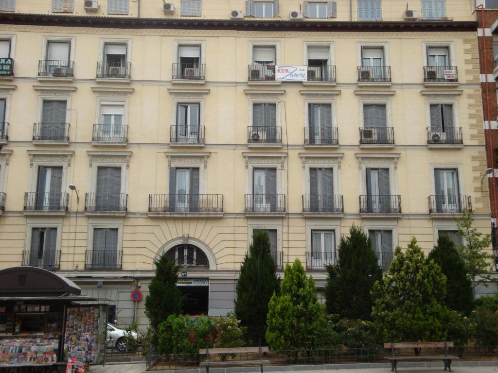 马德里萨莫拉旅馆的大型白色建筑,设有窗户和阳台