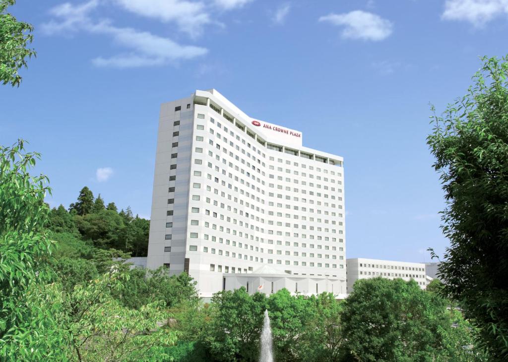 成田成田全日空皇冠假日酒店的一座白色的建筑,前面有一个喷泉