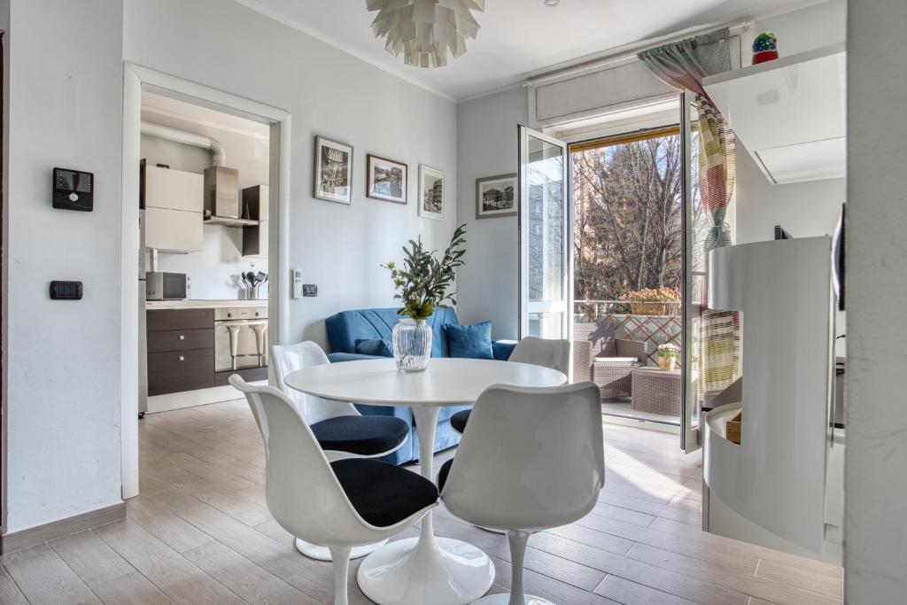 米兰ALTIDO Delightful flat with balcony的厨房以及带桌椅的起居室。